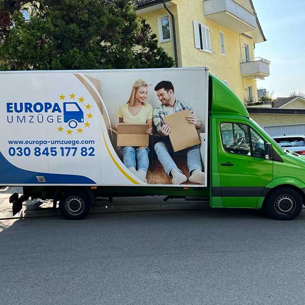Grünes Umzugsfahrzeug von Europa Umzüge vor einem Wohnhaus