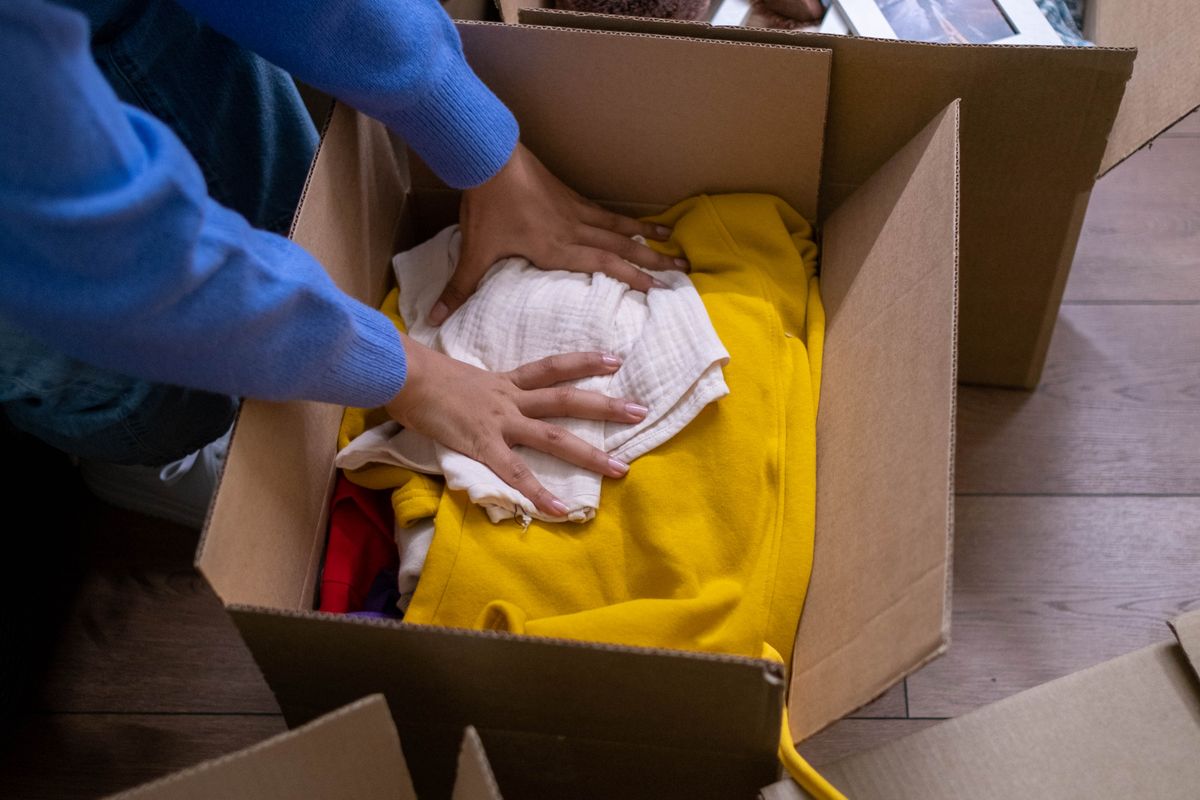 Behutsames Sortieren und Einpacken persönlicher Gegenstände beim Entrümpeln einer Messie-Wohnung